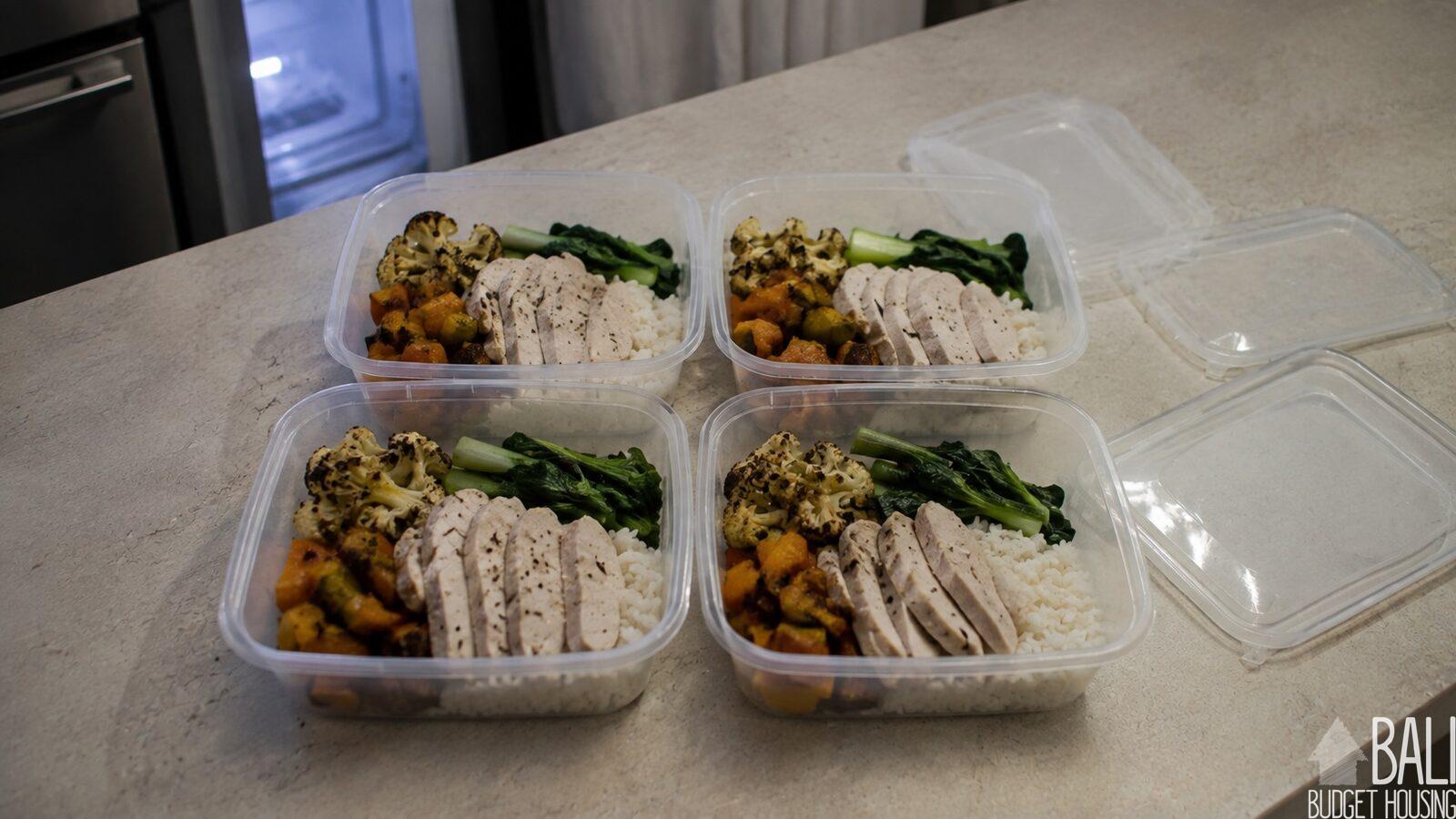 Prepared meals portioned into plain containers on a kitchen counter